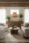 Candeeiro Suspenso Pinet suspenso no teto em ambiente de sala de estar boho-chic com luz quente e materiais naturais
