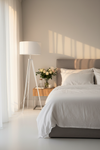 Candeeiro de pé branco em quarto elegante estilo boutique hotel com roupa de cama em linho