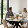 Mesa redonda Fiorella 120 cm en Travertino – ambiente con dos personas almorzando